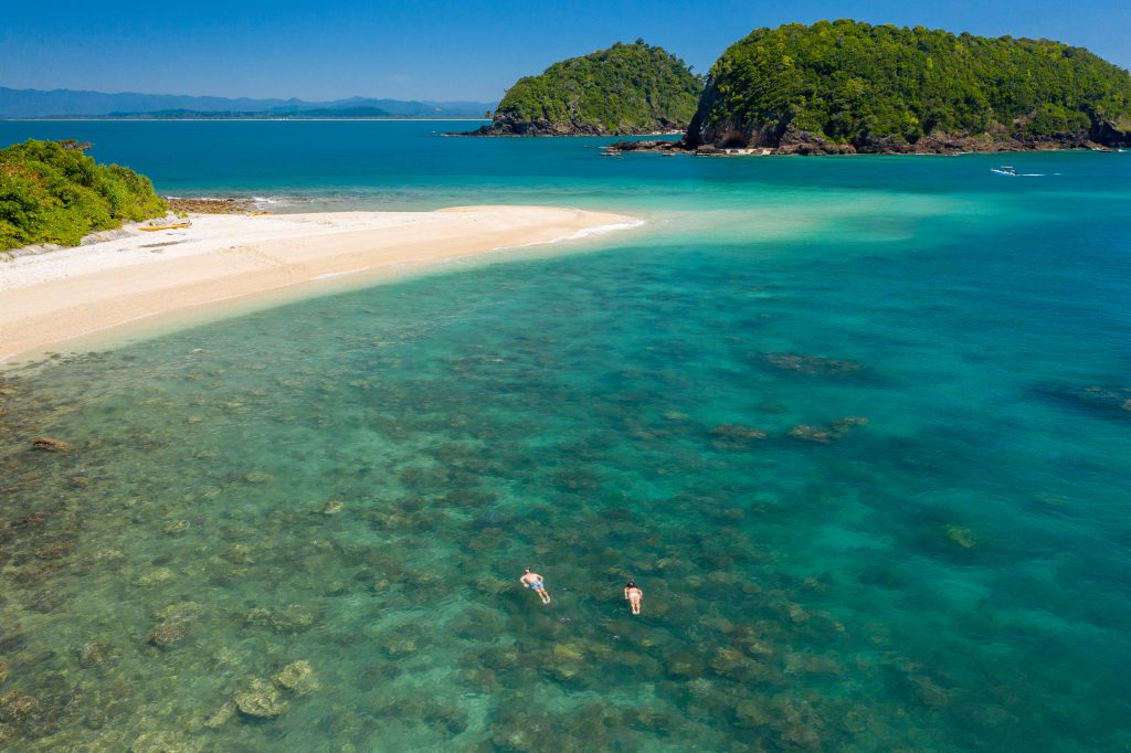 Aerial shot of two snorkelers at a tropical island